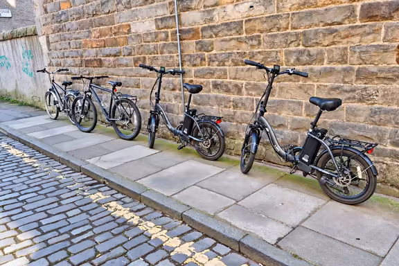 Bicicletas eléctricas plegables aparcadas en una calle empedrada de Edimburgo