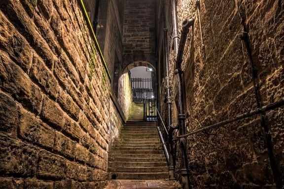 Narrow stone close with steps in Edinburgh's Old Town at night