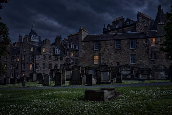 Greyfriars Kirkyard gravestones under a dark sky at night