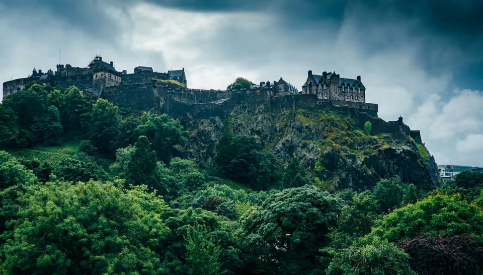 El Castillo de Edimburgo sobre Castle Rock rodeado de árboles