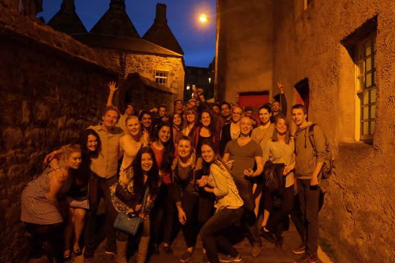 Pub crawl group posing in an Old Town close at night