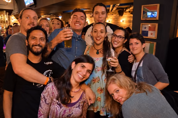 Friends raising their drinks inside a bar on the pub crawl